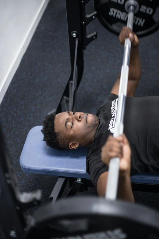 a man laying down on a bench at a gym