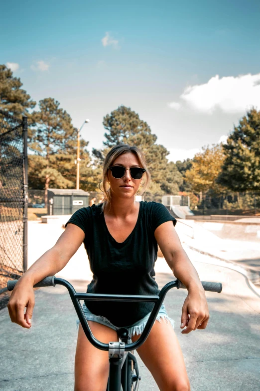 a  riding on a bicycle next to a skate park