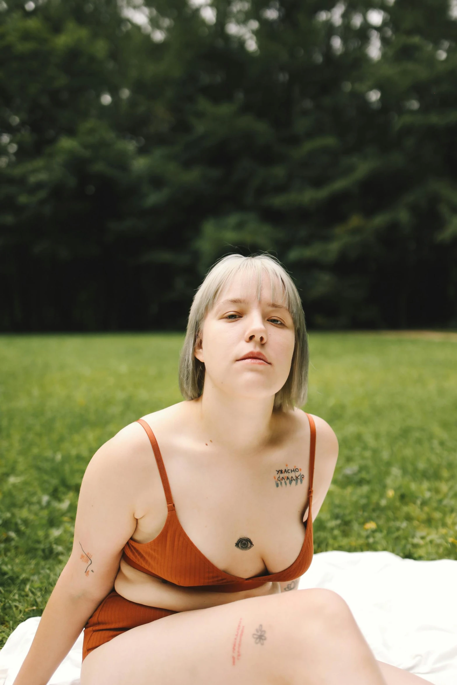 a woman in a brown dress sits on the grass