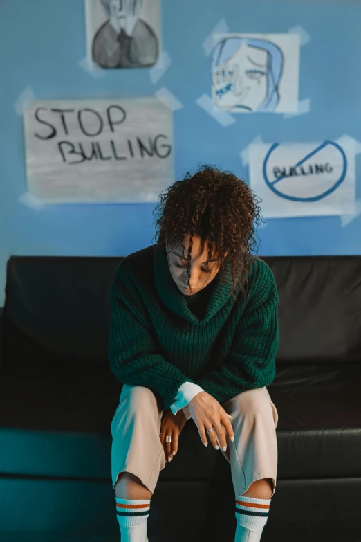 a person sitting on top of a black couch