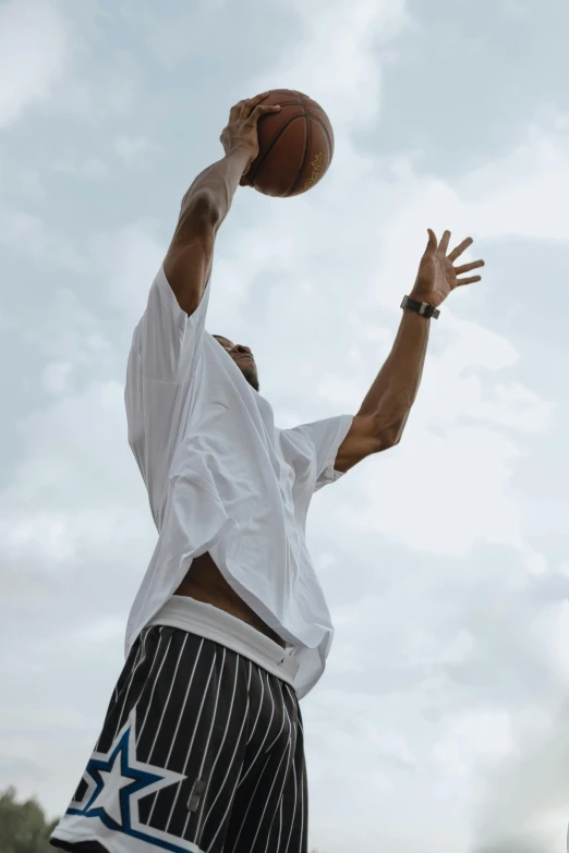 a man wearing a white shirt and black and blue shorts