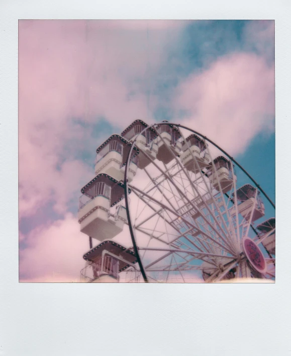 an old po of a ferris wheel against a blue and pink sky