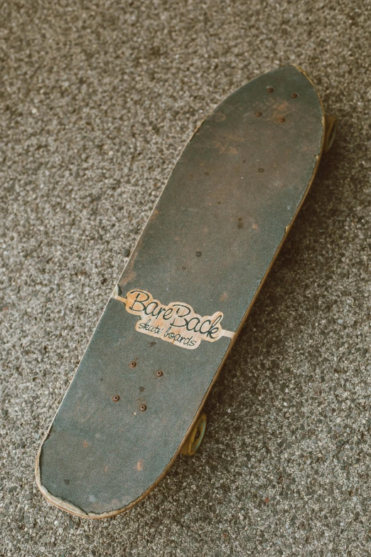 an old skateboard sits in a gravel area