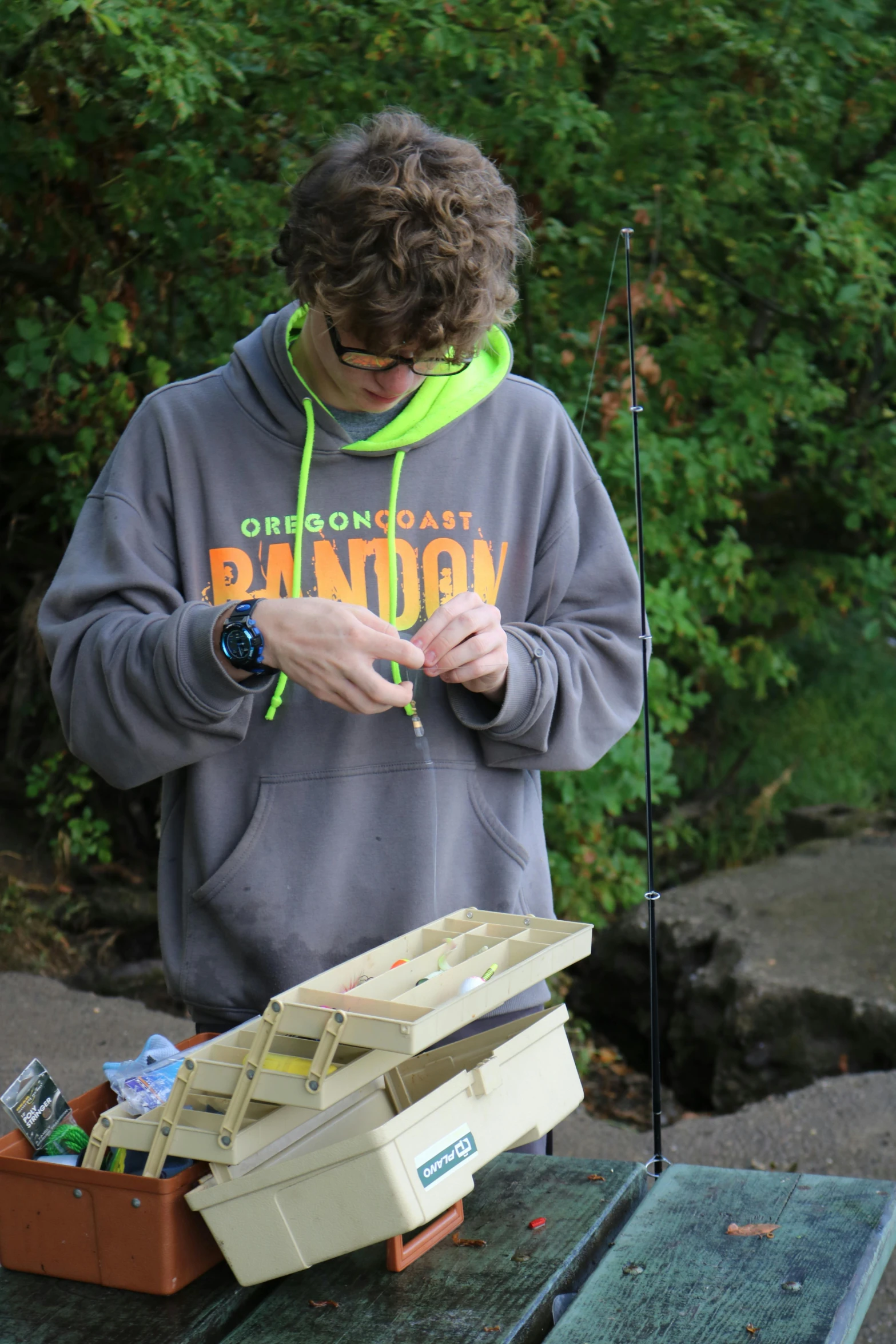 a man standing behind a box with a fishing rod in it