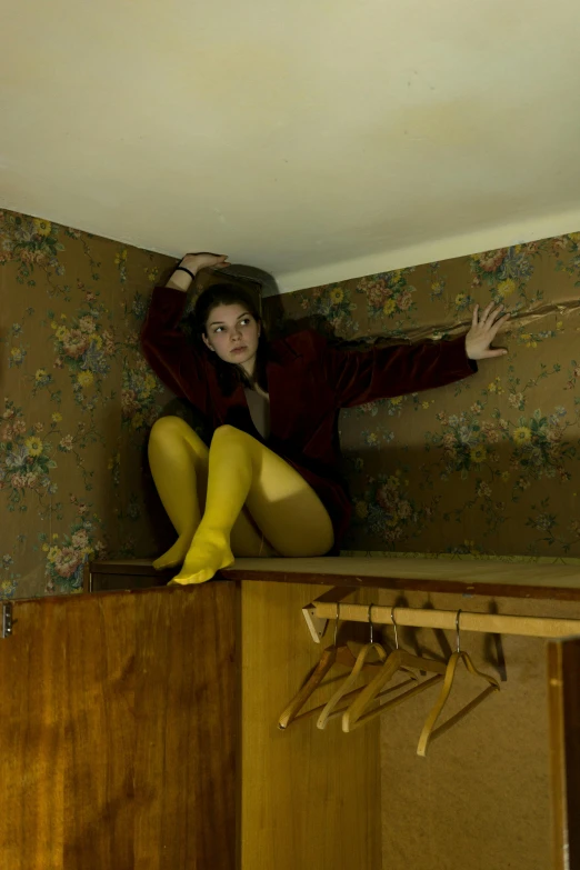 a woman poses on a wall with yellow tights