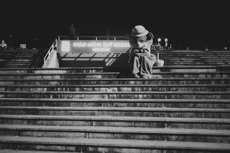 a person sits on top of some bleachers