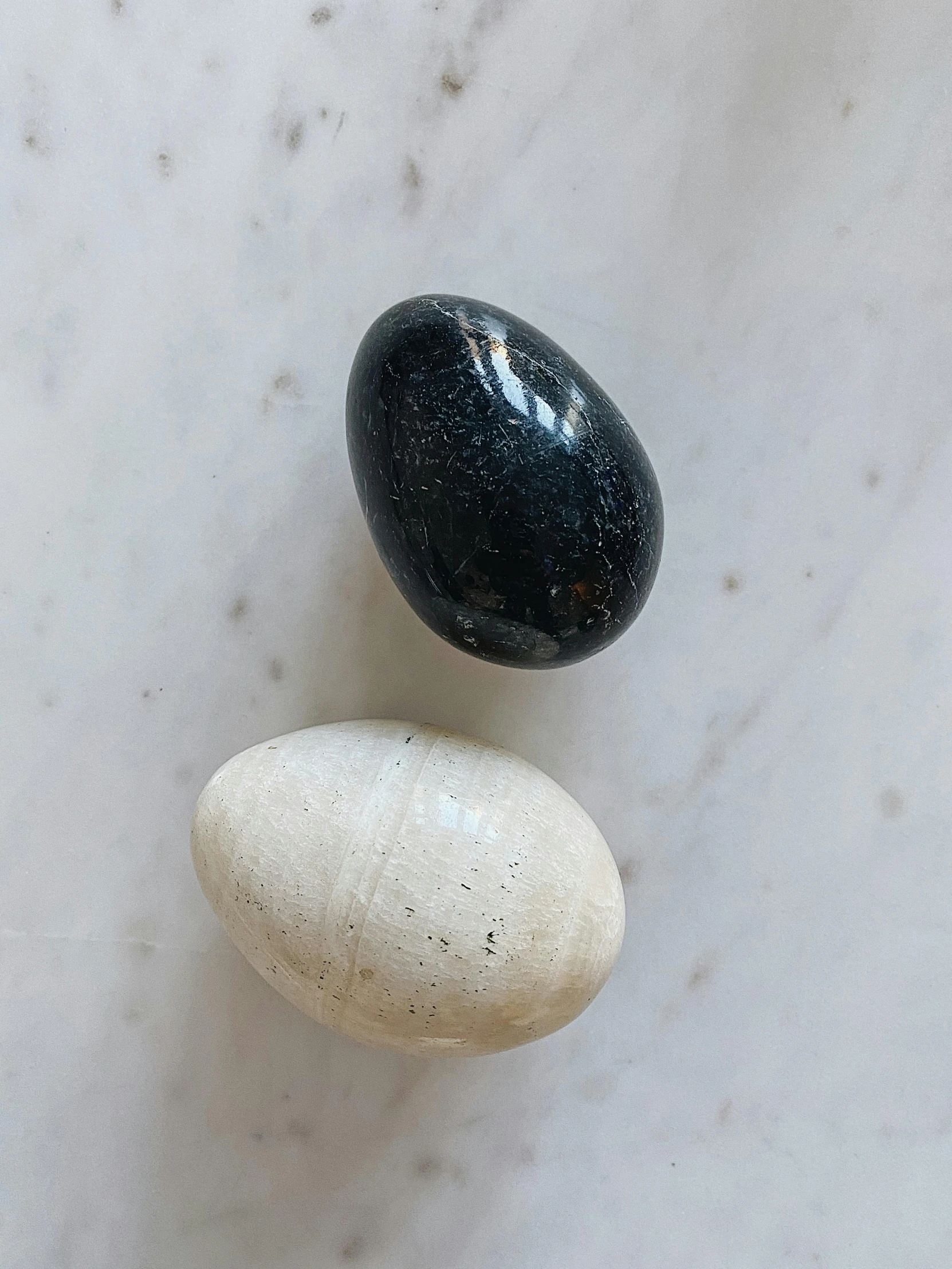 three black and white rocks sitting on top of a counter