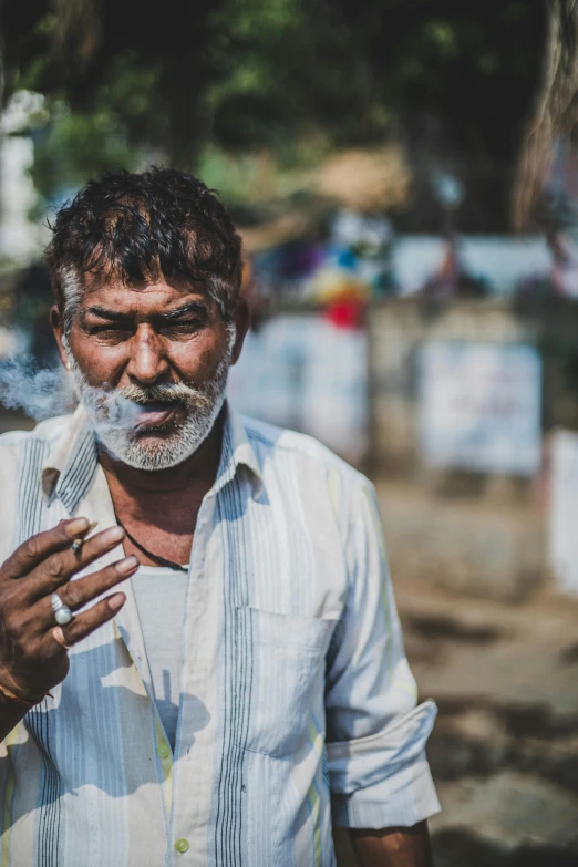 a man is standing outside smoking on a cigarette