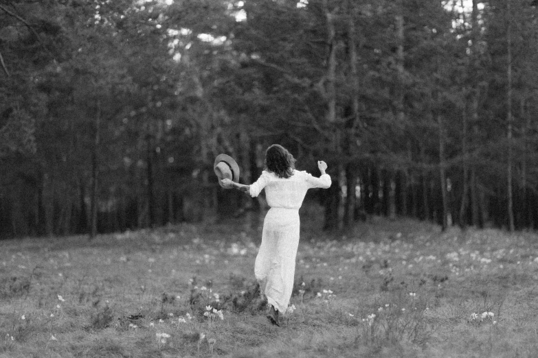 a black and white po shows a woman in the woods with a frisbee