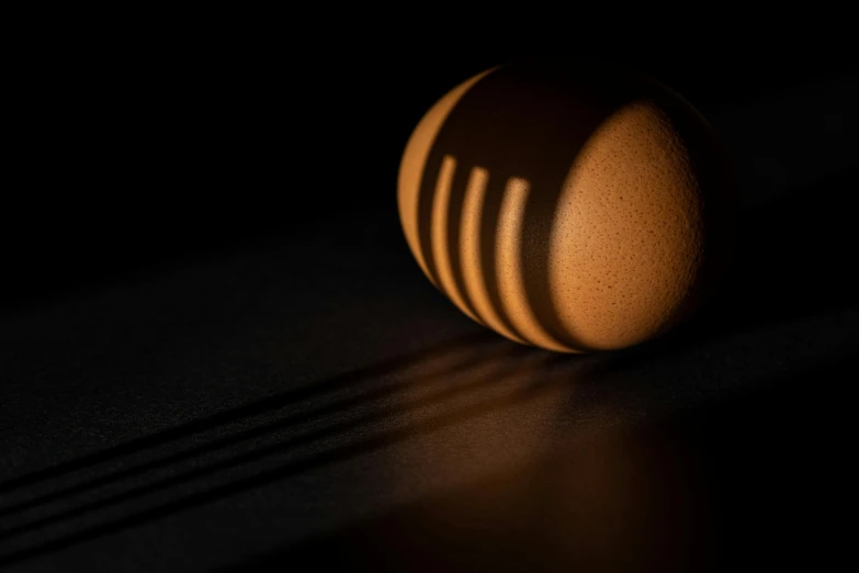 a wooden object laying on the floor with a dark background