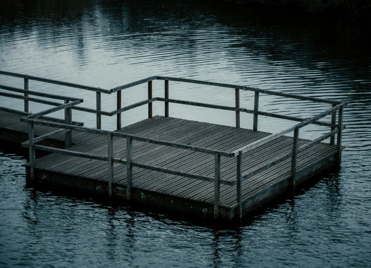 the water is calm while a metal dock sits in the middle of it
