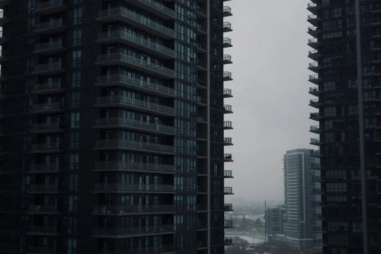 tall buildings next to each other with fog on them