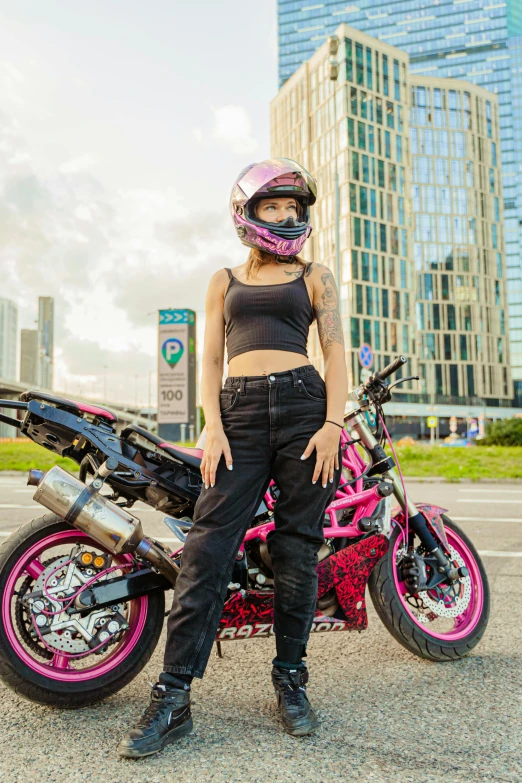 a woman is sitting next to a pink motorcycle