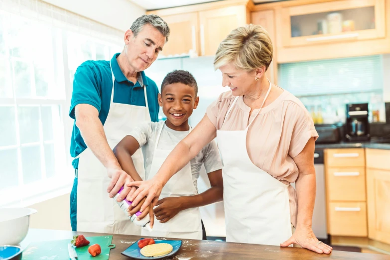 three people and a boy are standing in a kitchen