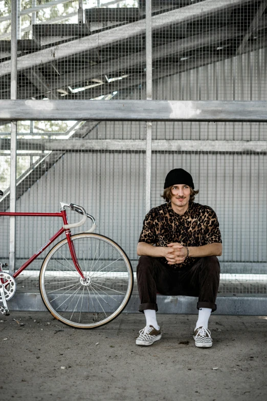 a man sitting on a floor next to a bike