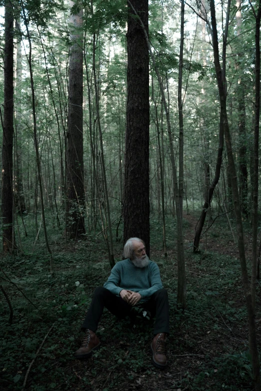 a man sitting in the middle of the forest