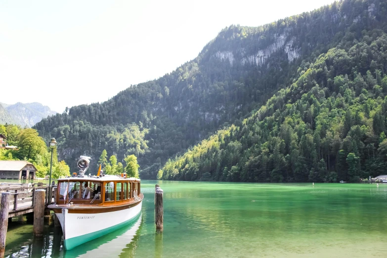 a long boat sitting on top of a lake in front of a mountain