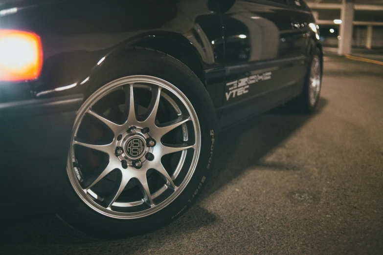 a car with chrome spokes on the rim and tires