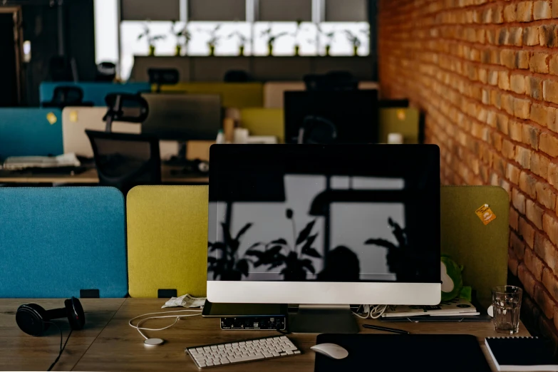 the computer desk is next to the wall of the room