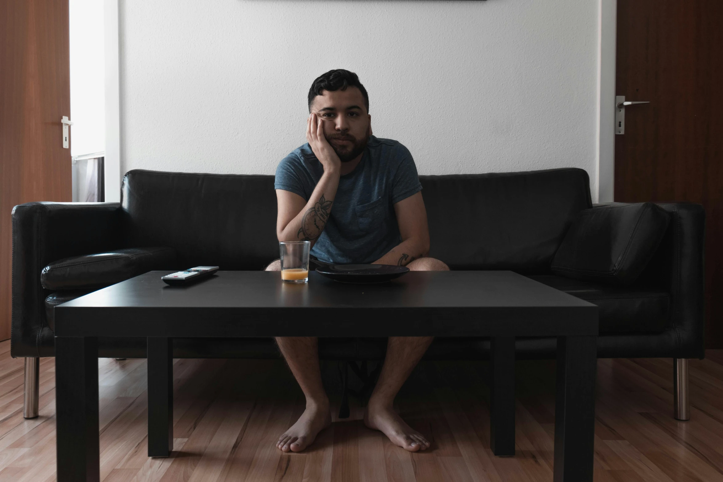 a man sitting on a couch while holding his laptop