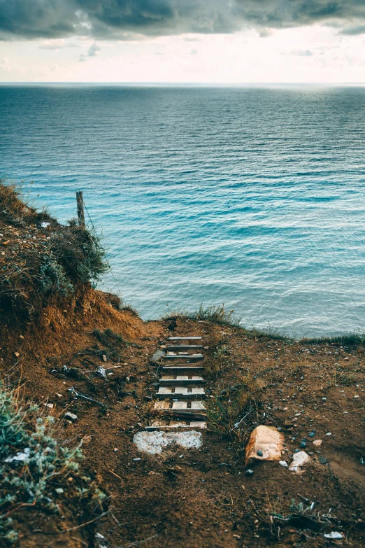 steps to the sea under a cloudy sky