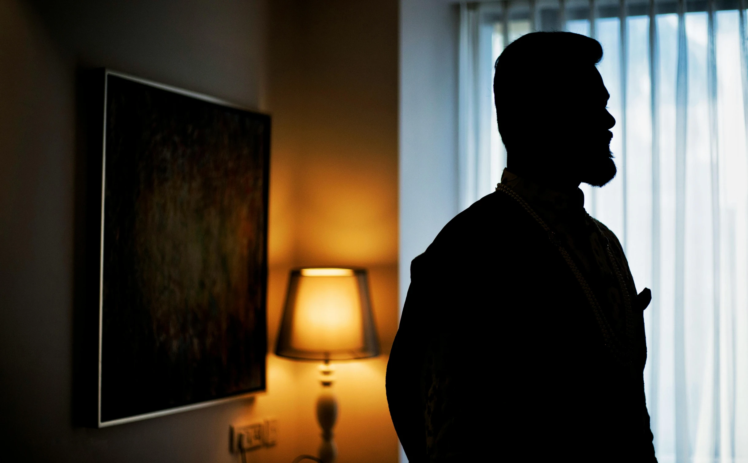 a man looking off into the distance in a dark room