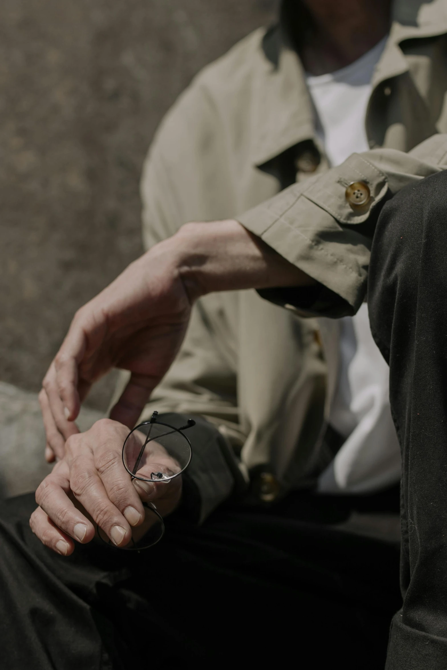 an old man wearing sunglasses sitting and looking away