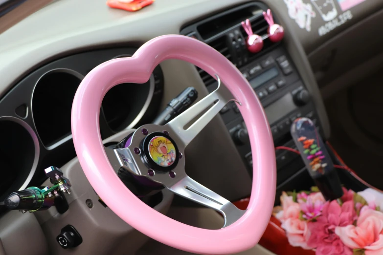 a steering wheel inside a car with decorative pink trims