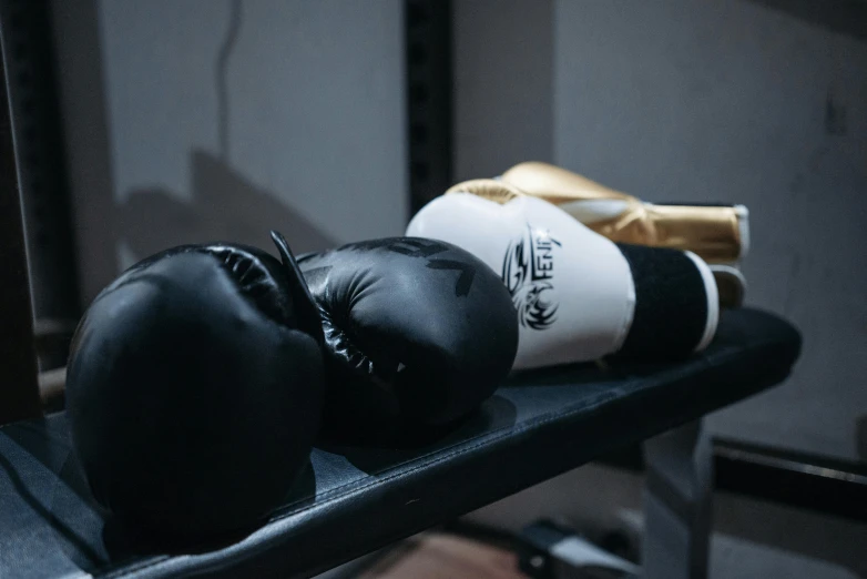 black and white boxing gloves sit on the bench