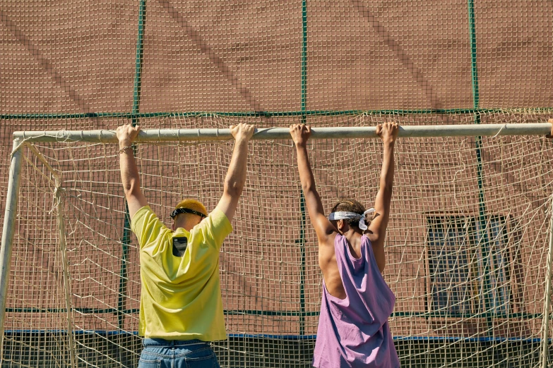 a man and a woman doing a trick on soccer net