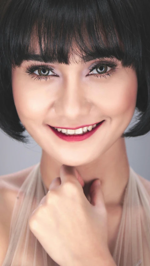 an asian woman with short hair smiling for the camera