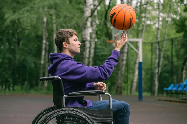 a boy is in a wheelchair about to throw a basketball