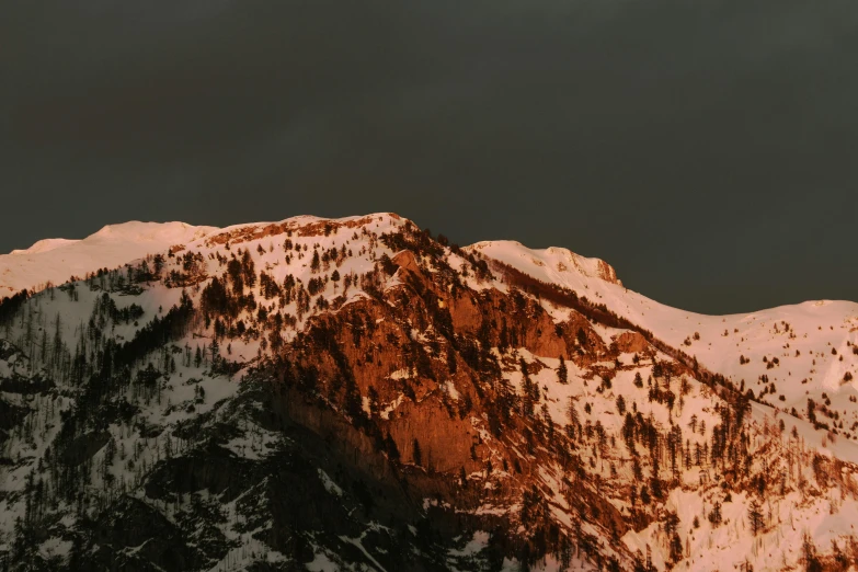 a lone snowboarder standing atop a snowy mountain