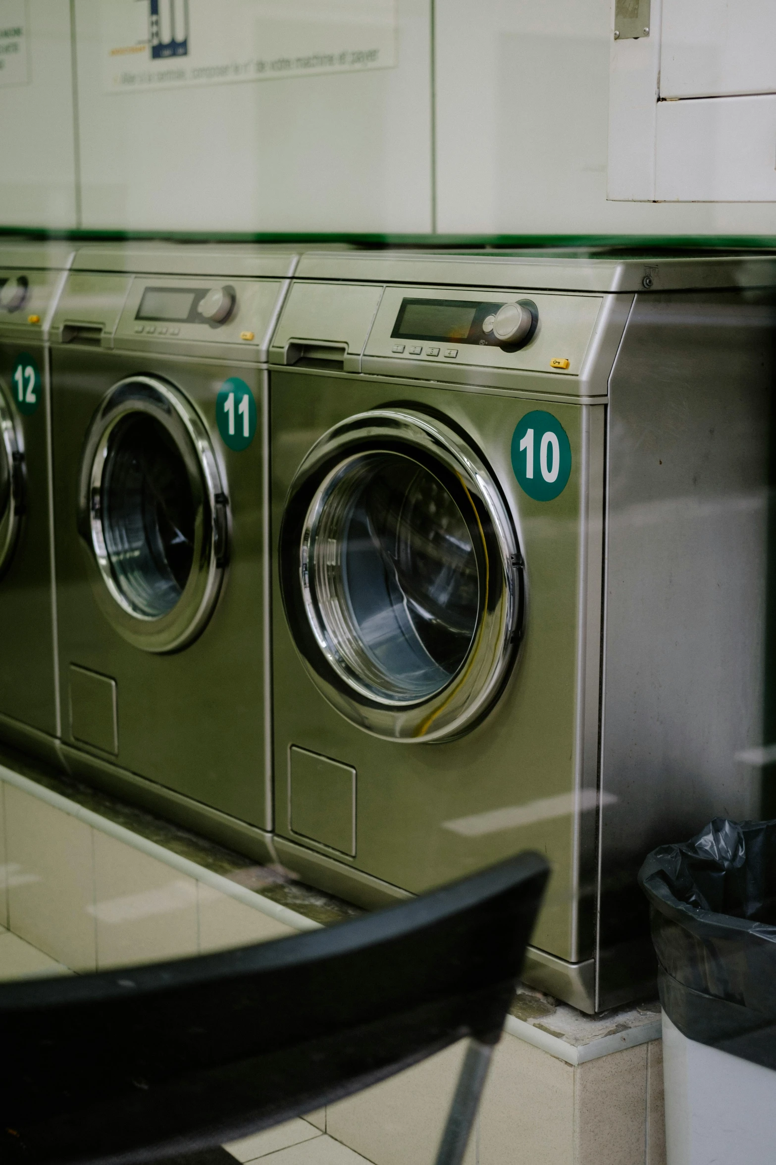 two washers sitting next to each other near some trash cans