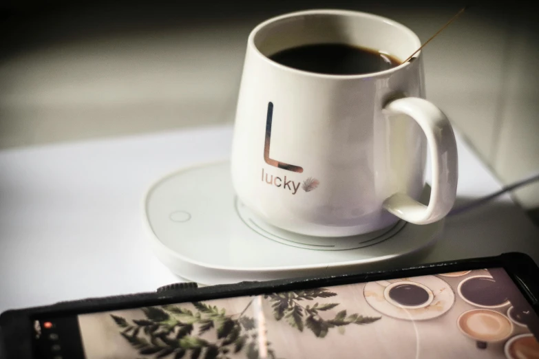 a cellphone and a mug of coffee on a table