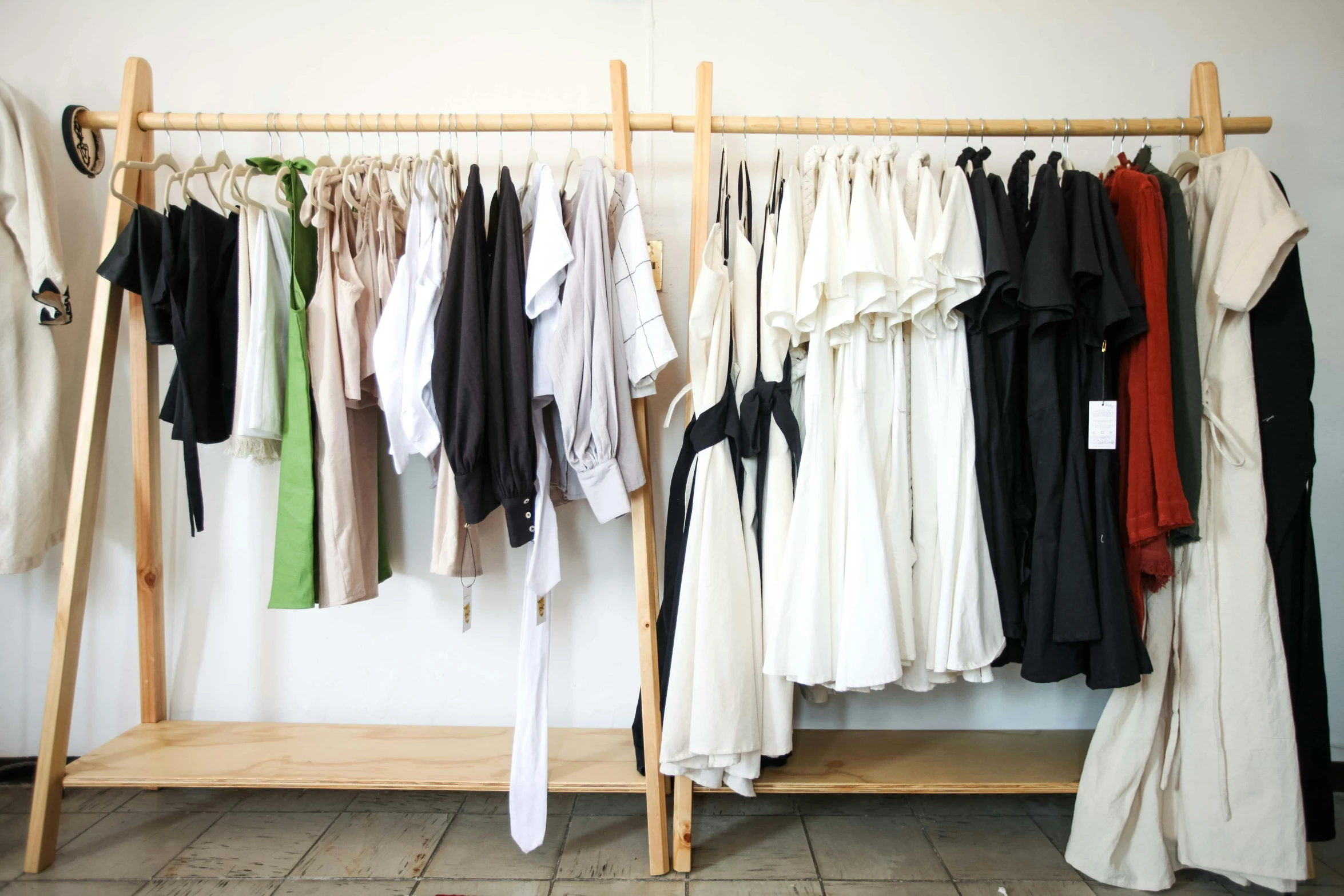 clothes are hanged on clothes rails and next to clothing rack