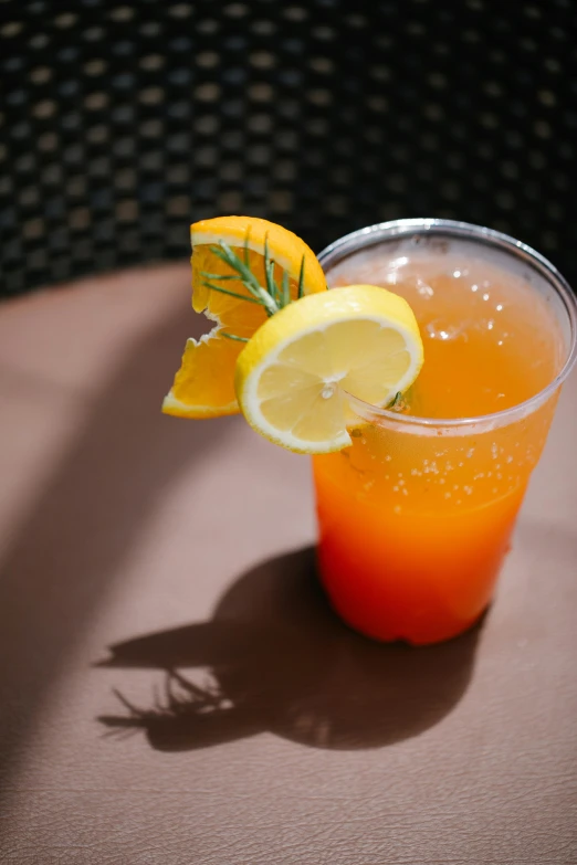 an orange and lemon cocktail is shown on a table