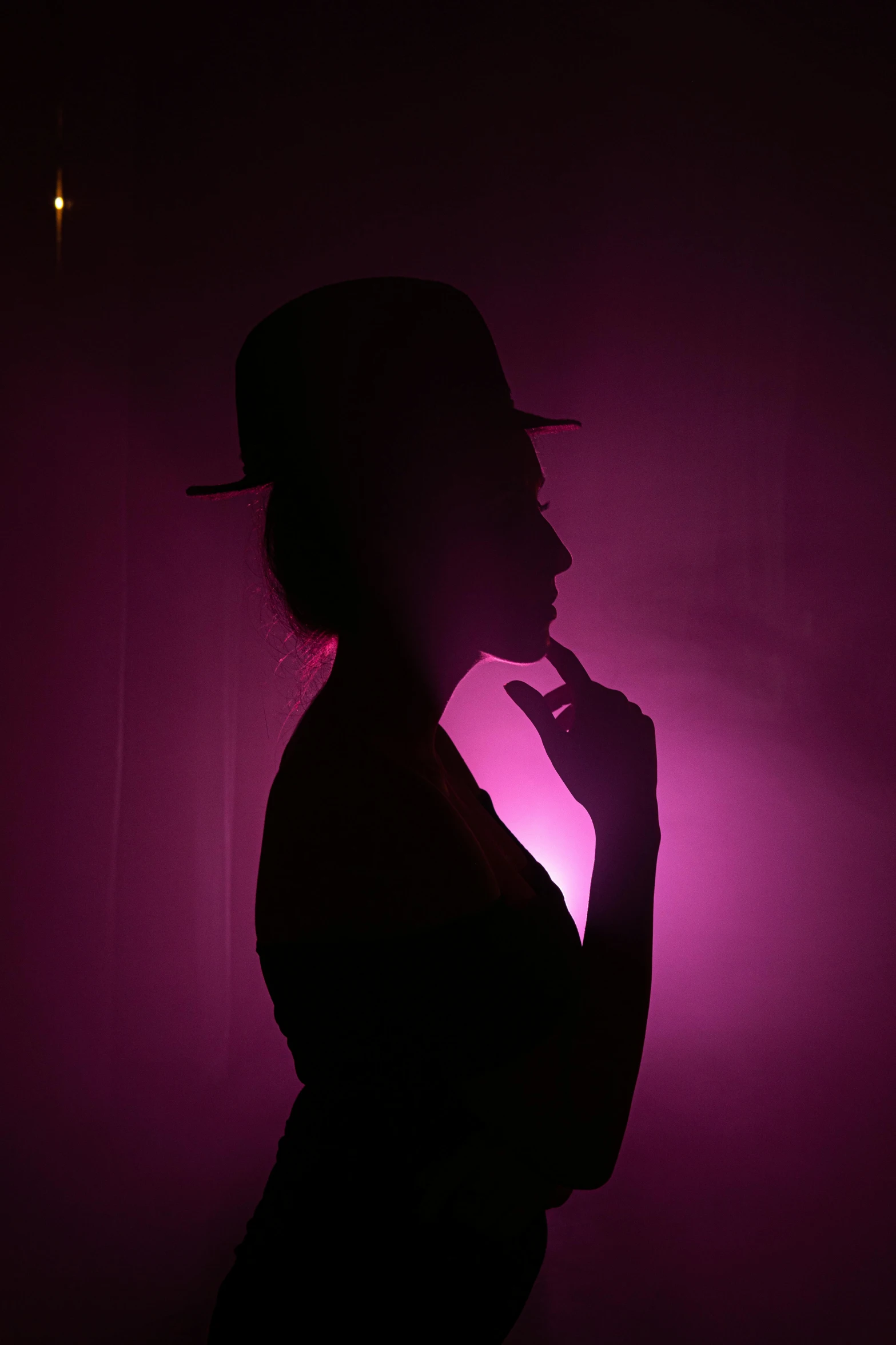 a woman standing in the dark smoking a cigarette