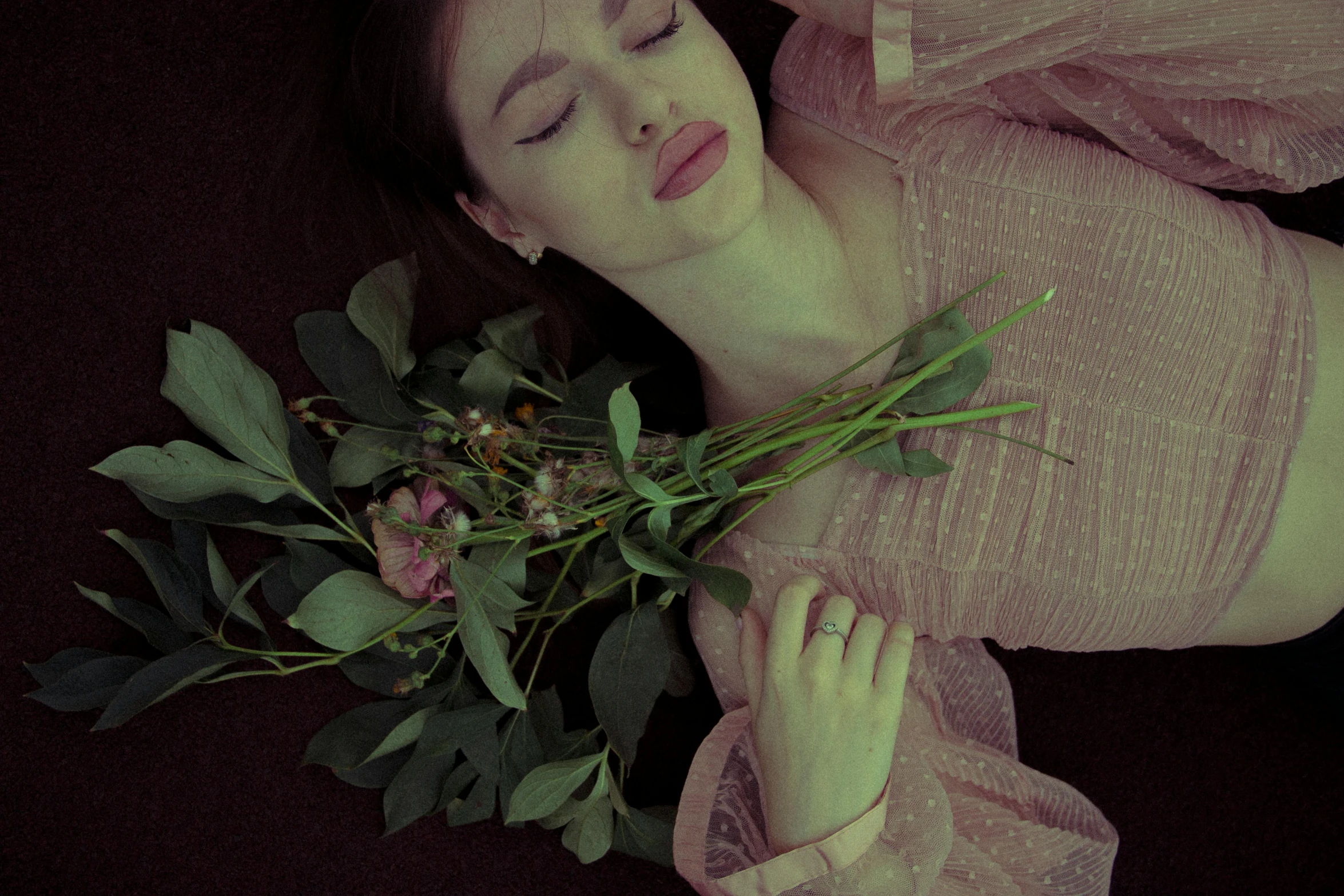 a beautiful woman laying on top of a pile of flowers