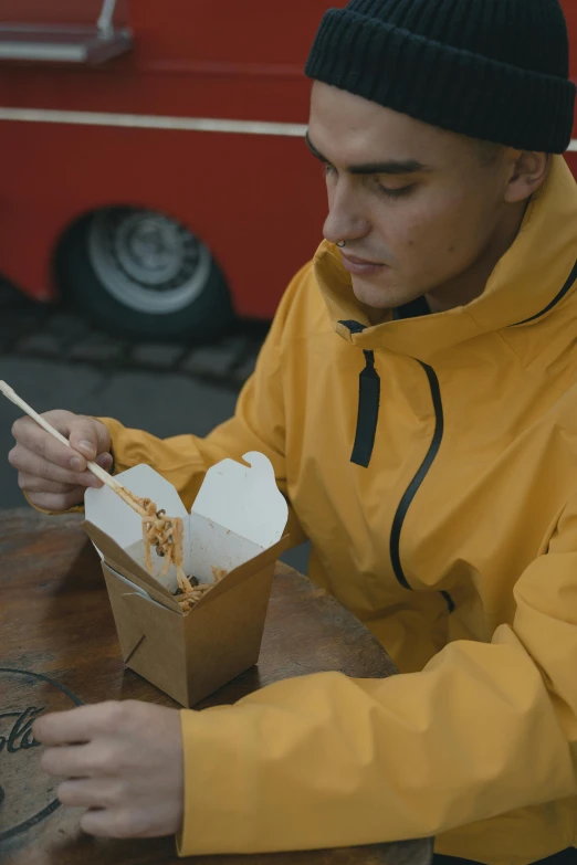 a young man sitting at a table eating a meal