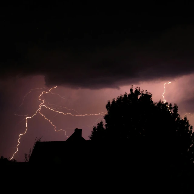 a lightning bolt strikes the sky over a house