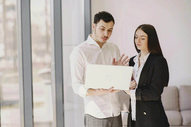 two people stand next to each other in an office space