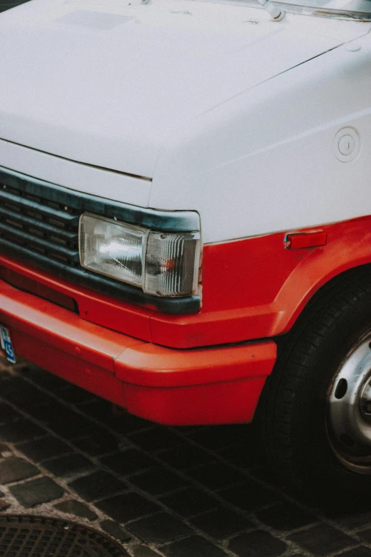 an older looking red and white car is parked