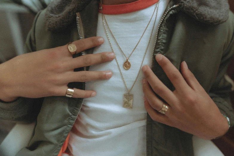 a person holding onto a phone with many rings on her wrist