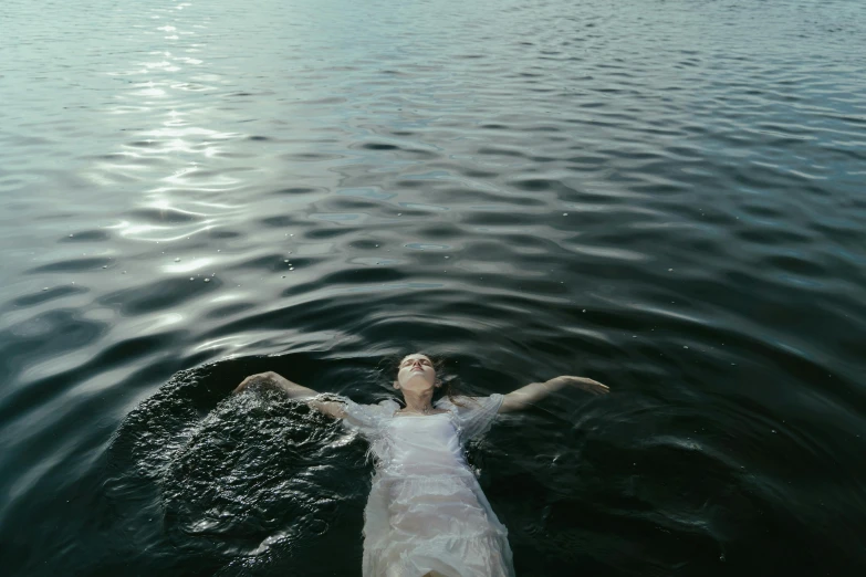 the young woman lies on her back in the ocean