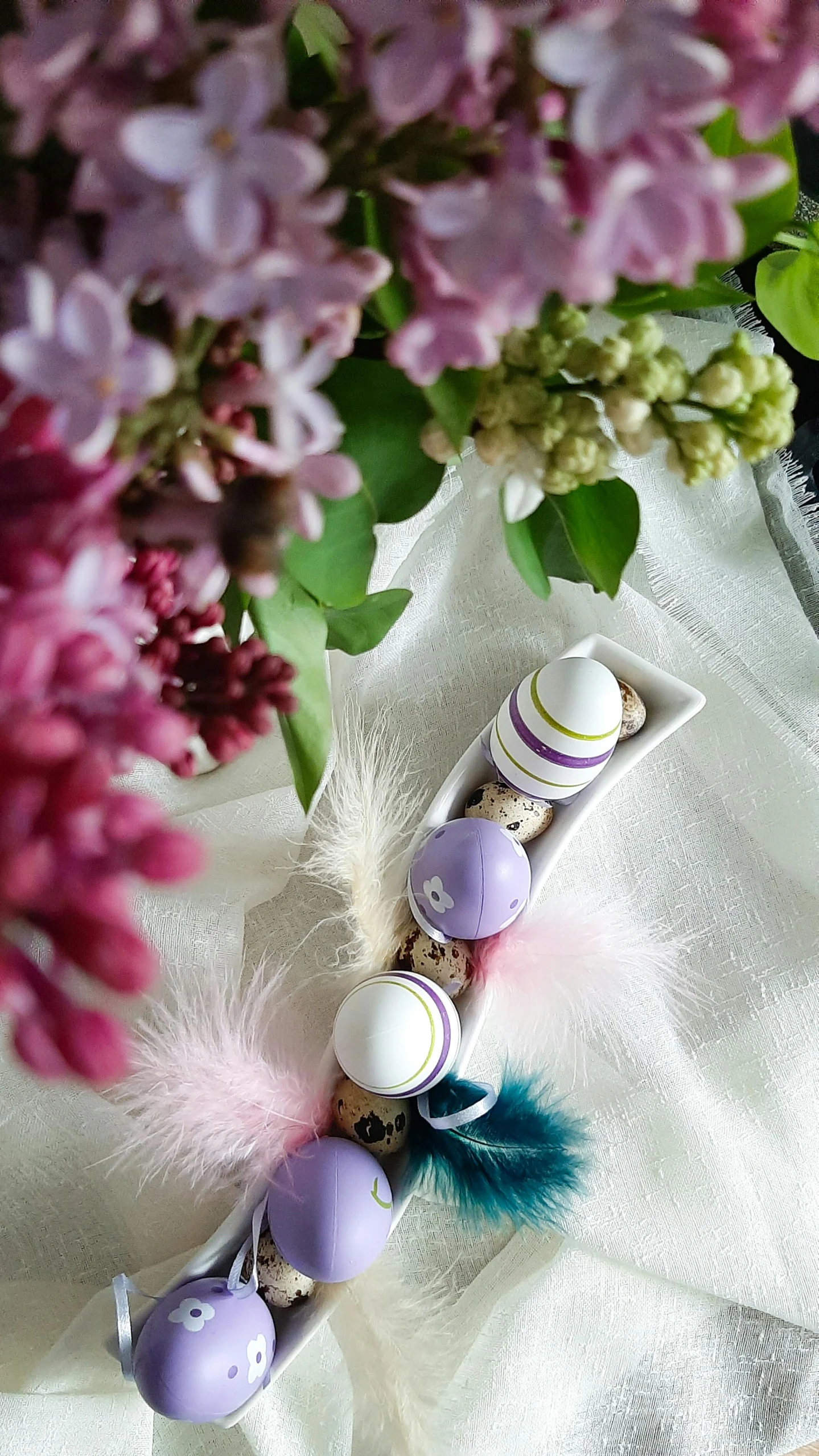 flowers and fake feather are arranged in containers