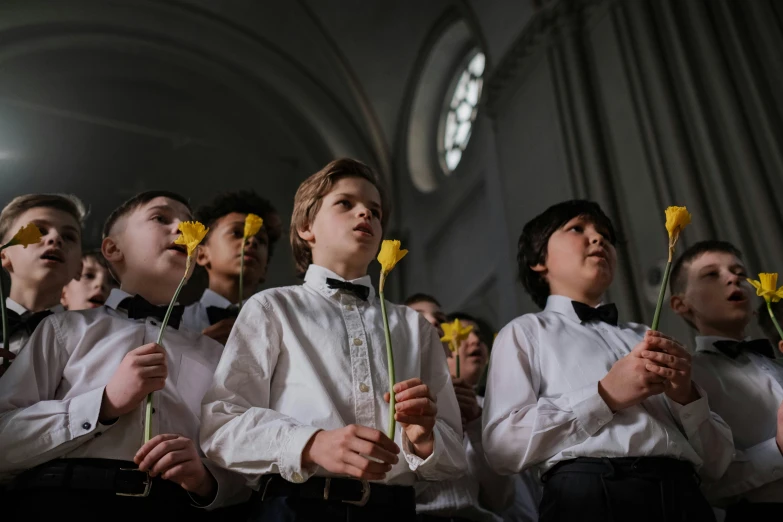 the choir is dressed in white with black collars and bow ties