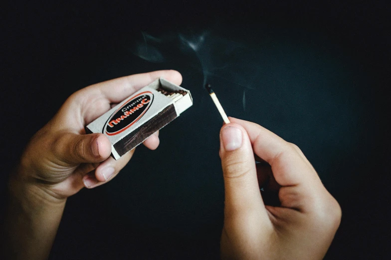 a person lighting a match with a match lighter