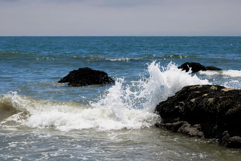 some waves crashing on some rocks in the ocean