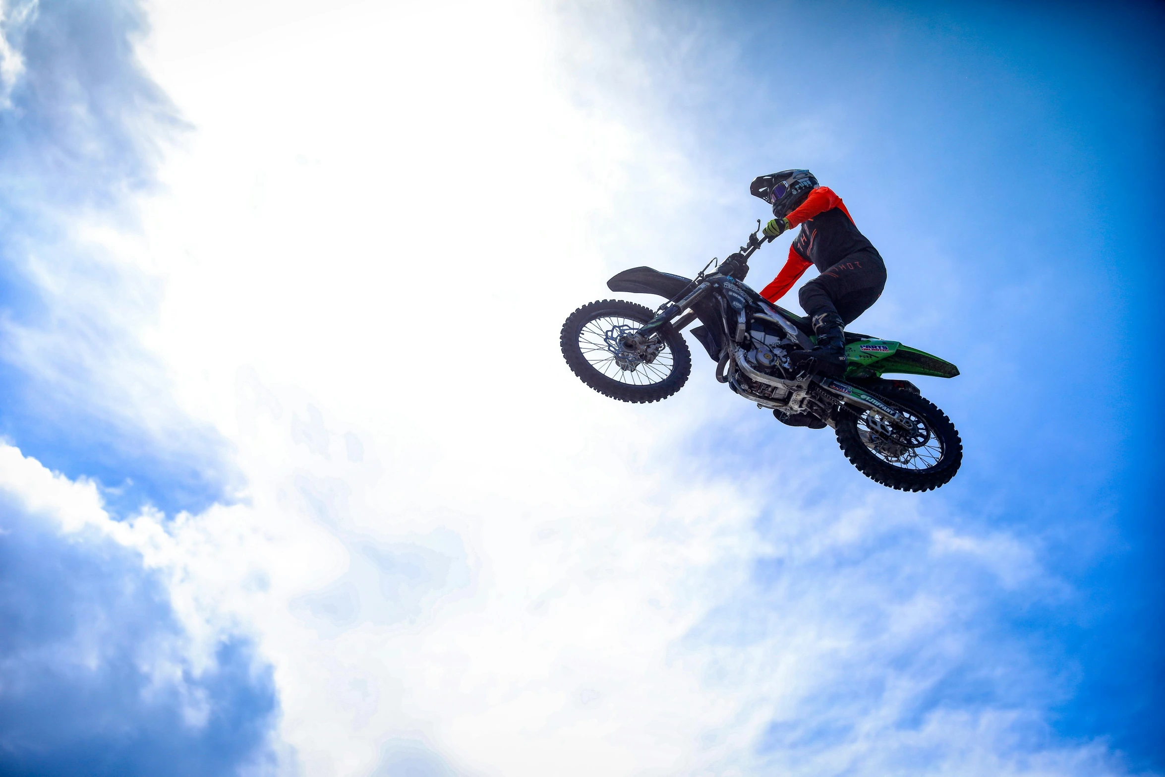 a man on a bike does stunts against the sky